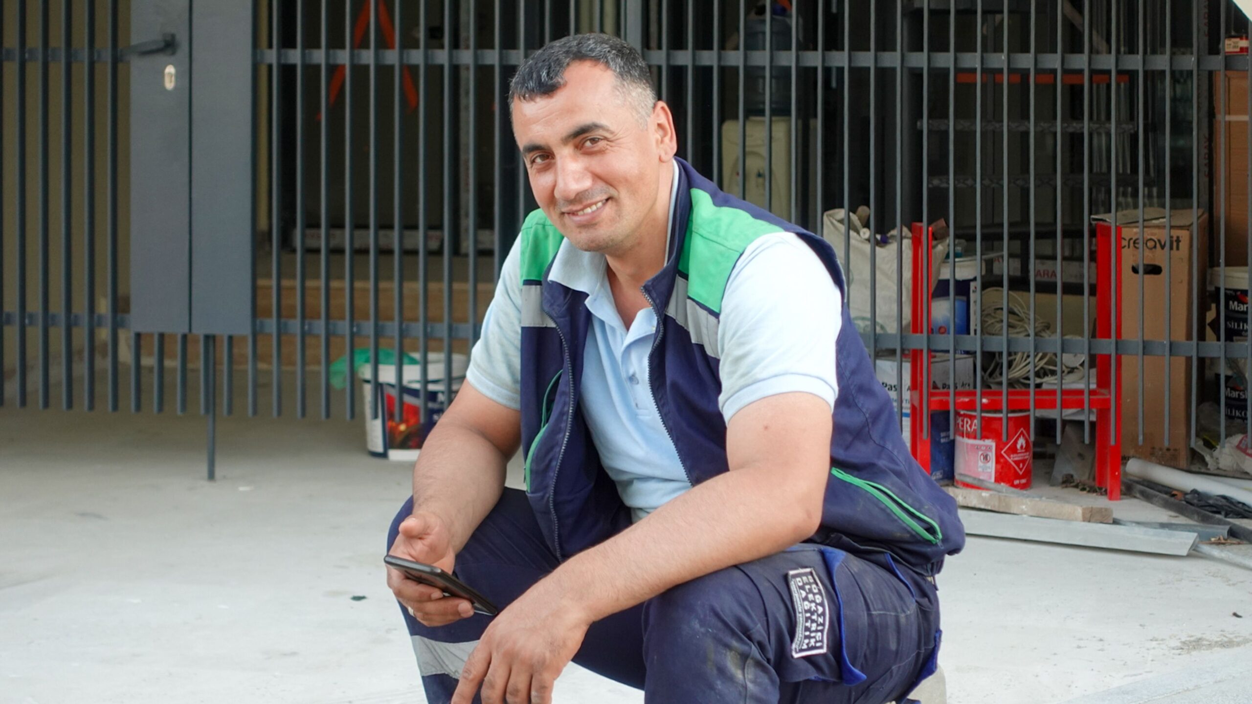 Construction worker using a smartphone at a building site, representing social media updates from the field.